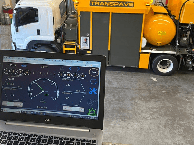 Transcoater Tack Coater in the background, and open laptop in the foreground with unit HMI replicated remotely on its screen.